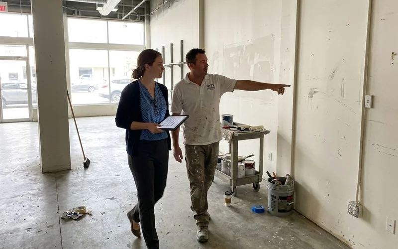 Facility manager walking a retail space with a painter during a site walk