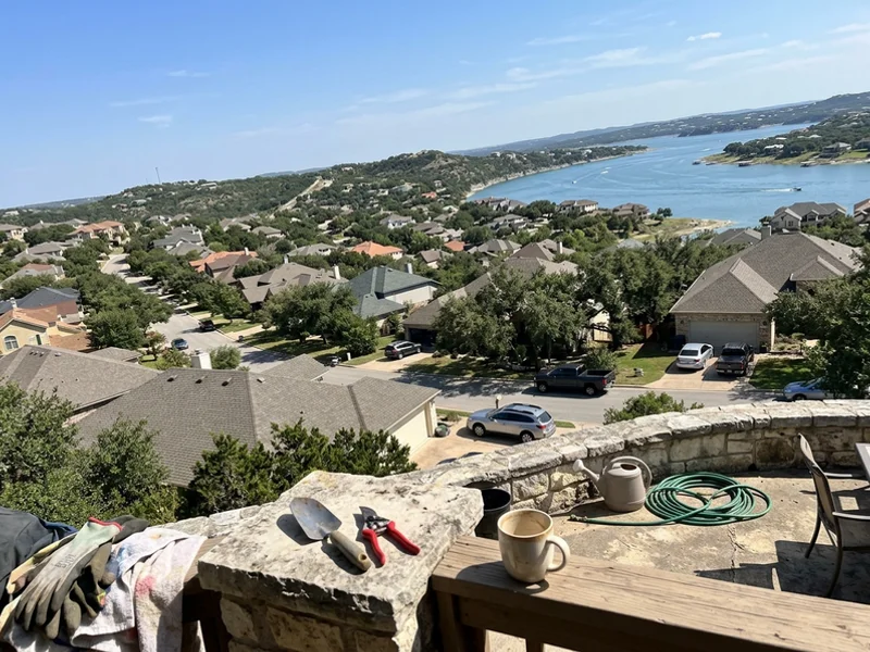 Austin Hill Country neighborhood rooftops with live oaks and Lake Travis in the distance
