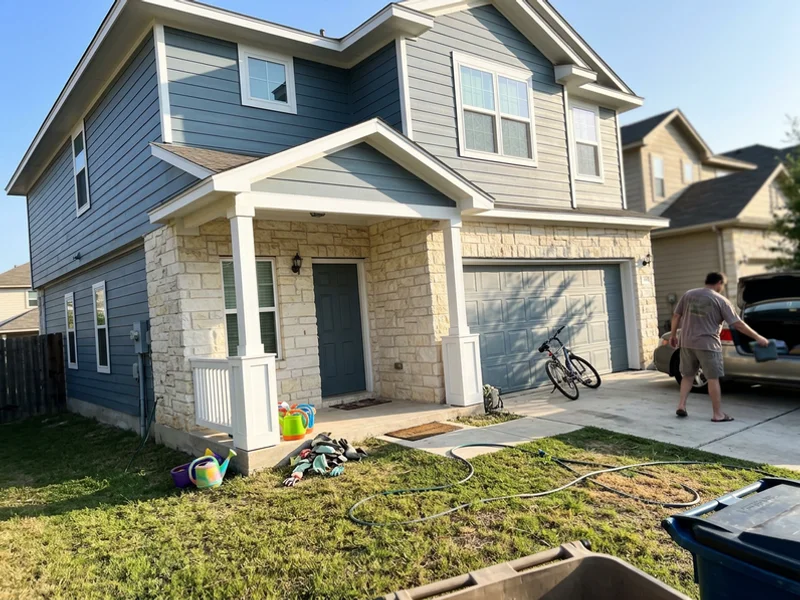Freshly repainted two-story Austin house with crisp trim around a limestone front