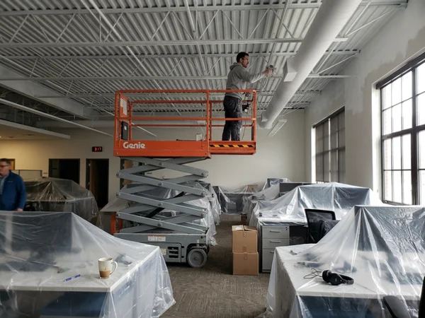 Scissor lift in an open-plan office for ceiling painting